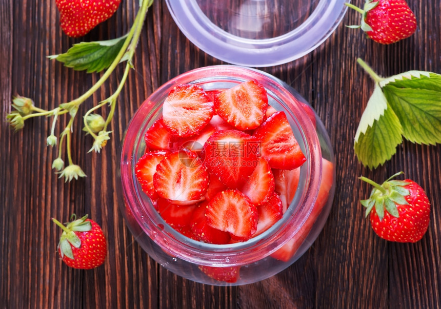 新鲜草莓放在玻璃窗和桌子上图片