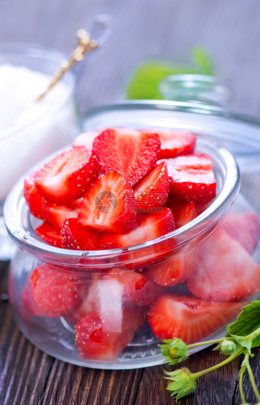 新鲜草莓放在玻璃窗和桌子上图片