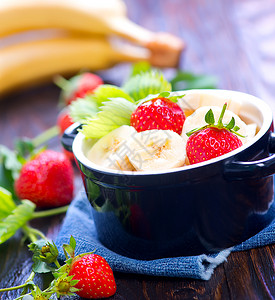 草莓和香蕉在碗里桌子上图片