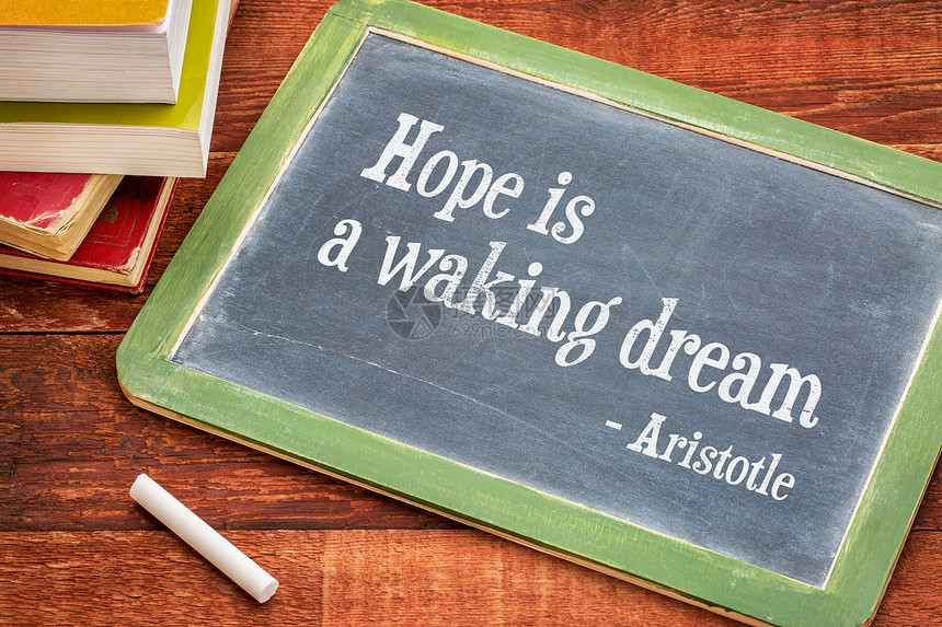 希望是一个唤醒的梦想亚里士多德的引文黑板上字白粉和一堆书图片