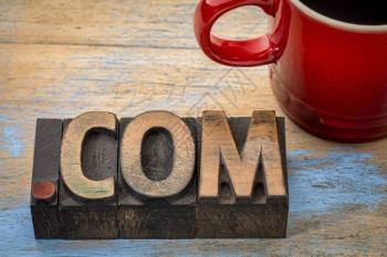 dotcom商务互联网域含有一杯咖啡的老式纸质印刷木材型块文本背景图片