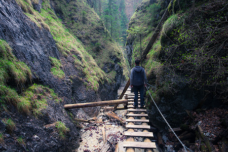一个人站在穿过岩石峡谷的路上图片