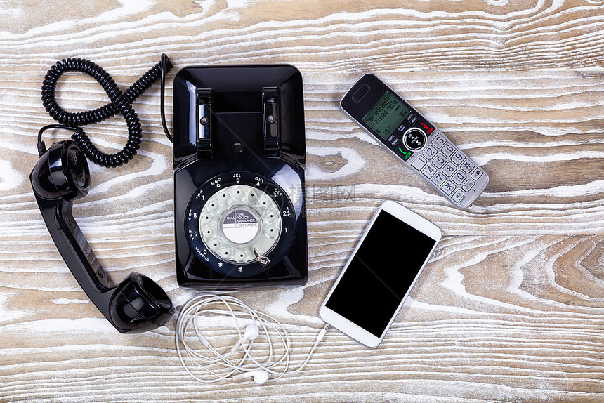 使用现代无线家和手机的旧式旋转电话图片