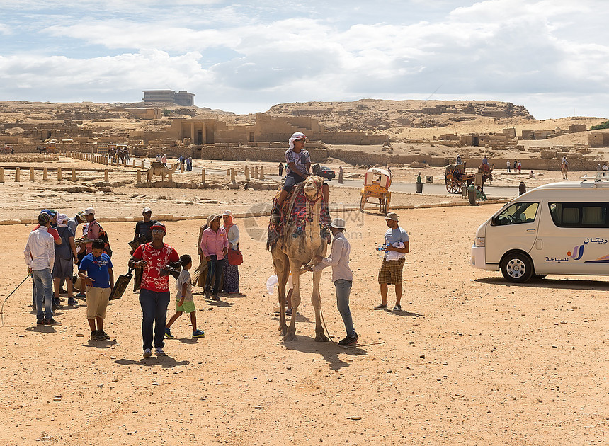 2015年8月3日埃及吉萨骆驼附近的旅游者和埃及沙漠金字塔的废墟图片