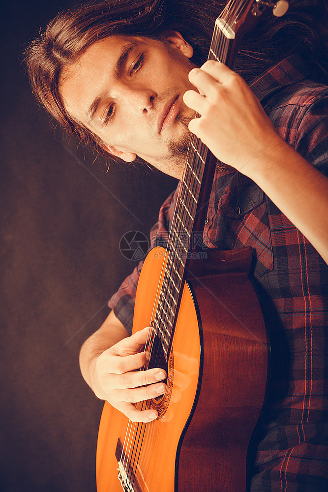 音乐爱好概念专注嬉皮士的吉他拿着乐器演奏这首歌图片