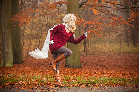 时装女郎跑在秋天公园森林里时装女郎带着飞行围巾跑在秋天公园森林里图片