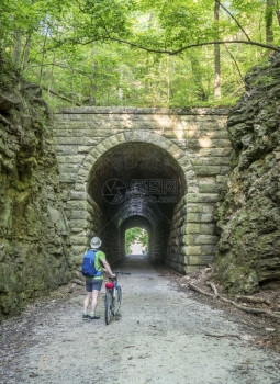 在密苏里州罗切波特附近的凯蒂车道上MKT隧中一名男骑自行车者凯蒂道是237英里的自行车道横跨密苏里州大部分地区从旧铁路改道图片