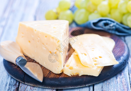 青葡萄和奶酪在切板上图片