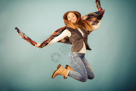 迷人的女正在跳跃运动的乐趣和时尚概念长发的漂亮女孩穿着牛仔裤和围巾图片