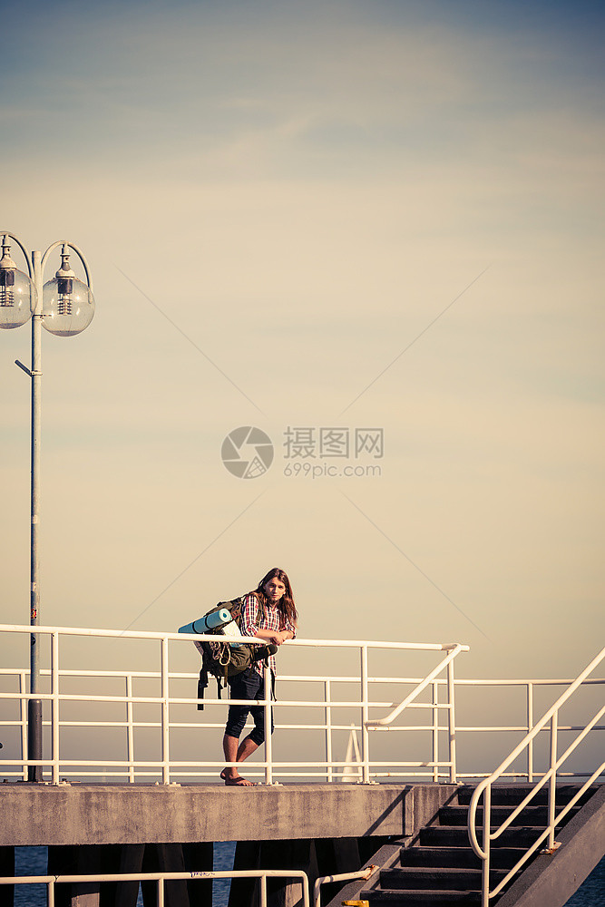 在码头的徒步旅行者背包车在海边骑背包的年轻人冒险和旅游美丽的海景图片