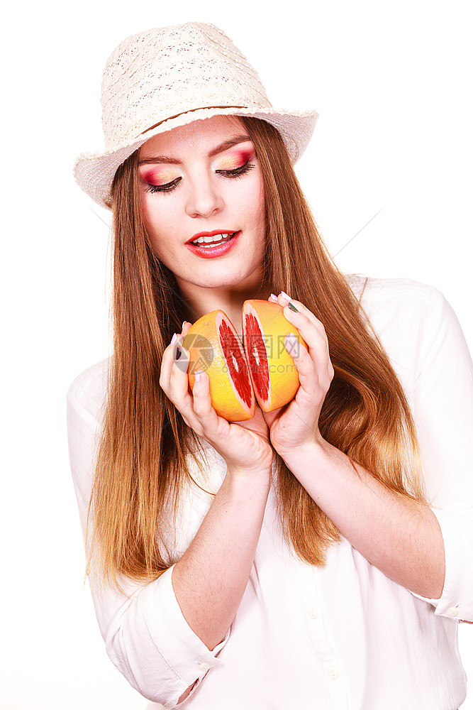 妇女手中握着两半葡萄果柑橘水有吸引力的长发女孩有色眼睛将两半葡萄果柑橘水握在手上健康饮食品暑假概念图片