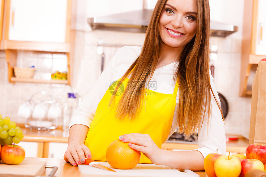 厨房的笑妇美食饮水果自然概念厨房的笑妇女师靠在一堆水果和厨房用具旁边的柜子上图片