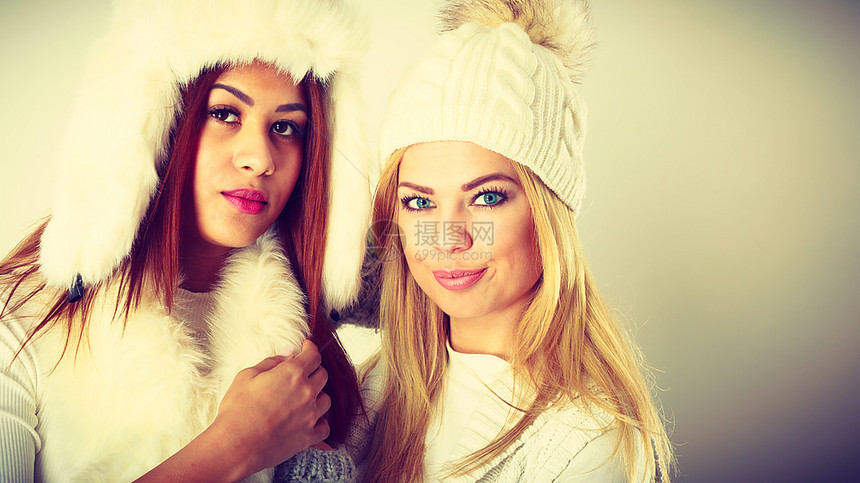两个穿冬衣的女人时装模特的概念金发和混合种族的穿着温暖衣服的女士图片