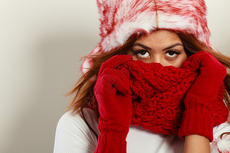 时装雪花间人们的概念穿红冬服的妇女穆拉托模特身着温暖的帽子和围巾图片