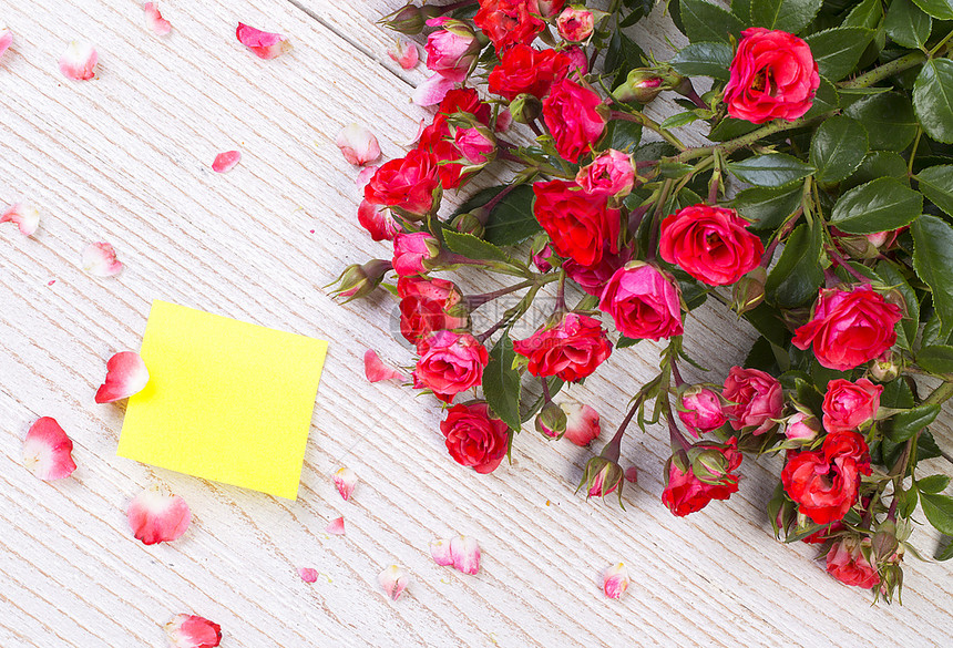红玫瑰在木制餐桌背景上纸作为复制空间浪漫花主题图片