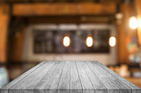 透视黑白木桌顶上咖啡店面的抽象背景模糊图片