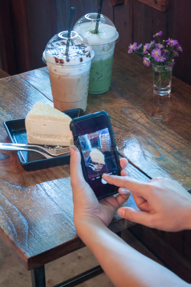 在咖啡店里用智能手机的闭合女人股票照片图片