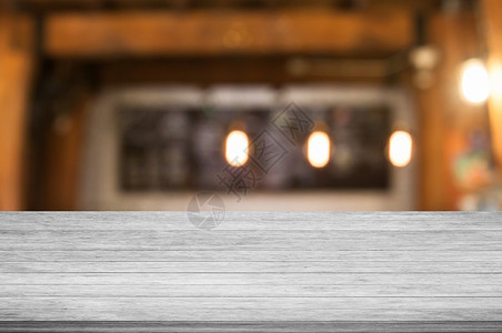 黑白木桌顶端的咖啡店面模糊的抽象背景图片