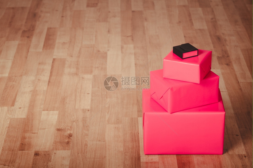 红黑盒在地板上帮助和赠送概念三个红礼物盒和一个小黑盒在室内地板上图片