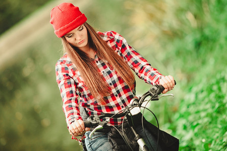 年轻女子骑着自行车在森林公园停顿图片