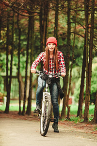 年轻女子骑着自行车在森林公园停顿图片