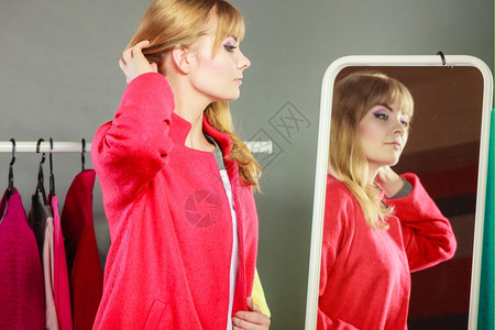 女孩穿新衣看着镜子漂亮的快乐女人照着镜子柜的物背景图片