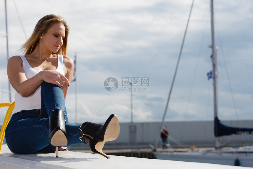 坐在码头上的女人休息和放松年轻的美人新鲜空气在码头上放松时髦的金发女孩在户外待着图片
