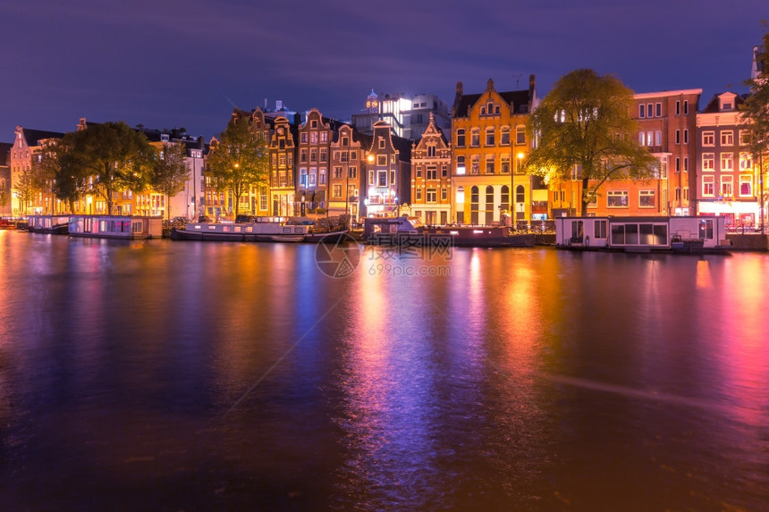 阿姆斯特丹运河典型的荷兰夜里装有多色反光的荷兰码头房屋和豪船图片