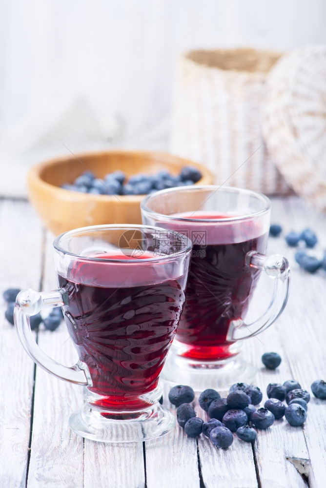 蓝莓果汁在玻璃和桌子上图片