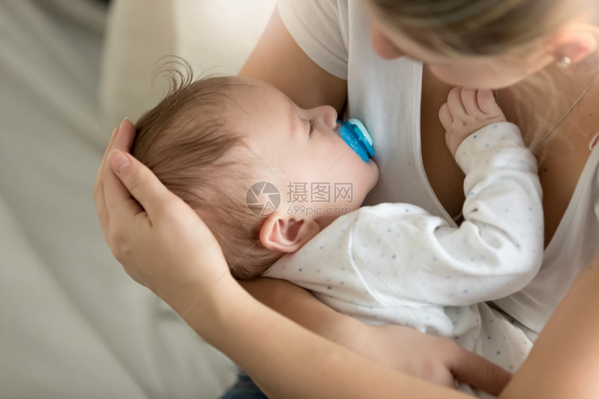 年轻母亲与在卧室睡觉的婴儿近视图像图片