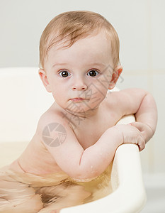 可爱小男孩洗澡和看相机的近视肖像图片