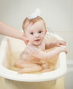 可爱的婴儿男孩肖像头上有泡沫洗澡时间图片