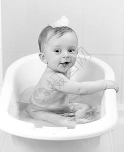 黑白的男孩坐在浴缸里欢快的男孩子喜悦黑白肖像图片
