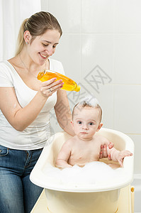 母亲用洗发水给婴儿洗头图片