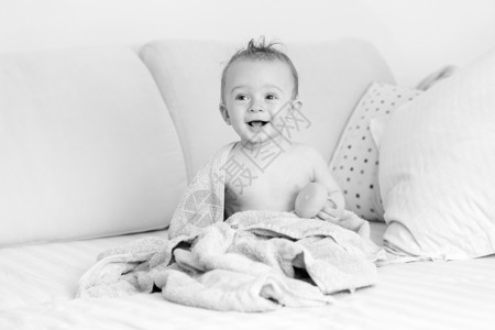 洗完澡后坐在床上的笑婴儿黑白肖像图片