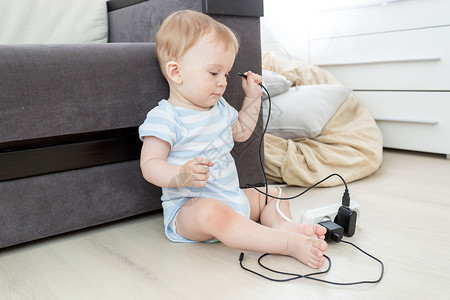 10个月大的婴儿男孩从电源扩展线上拉缆图片