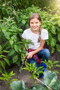 快乐的年轻女子肖像工作在花园与大犁沟高清图片素材