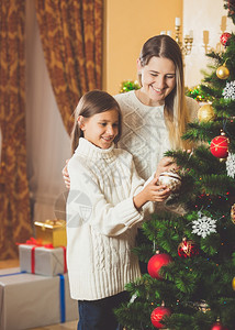 美少女帮助母亲装饰圣诞树图片