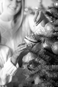 女儿帮助母亲装饰圣诞树的黑白画面图片