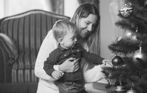 圣诞树上装饰的幸福母亲和小男孩的黑白画像图片