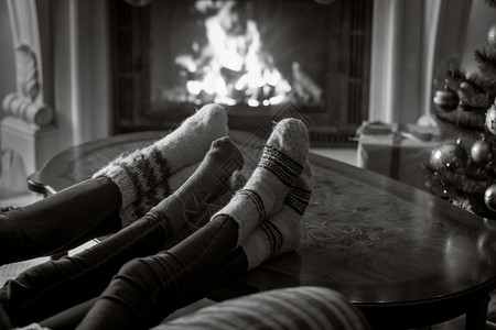 黑白两一对家庭近视形象穿着羊绒袜子在燃烧的壁炉中休息图片