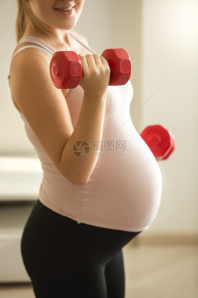 孕妇举起哑铃的近照图片