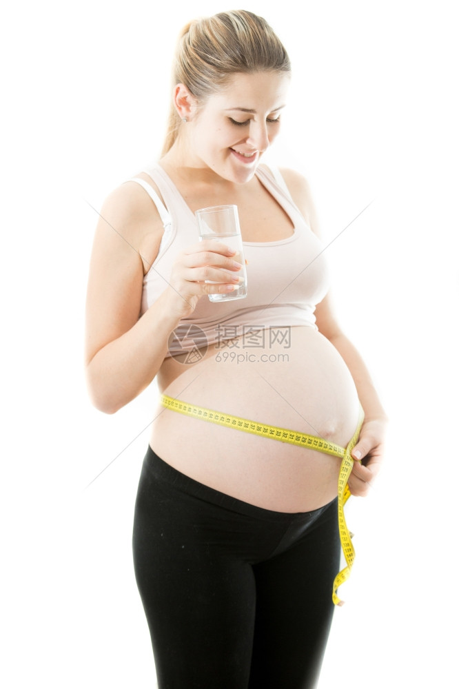 快乐的孕妇用测量胶带腹部的肚子肖像图片