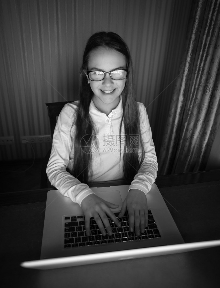 坐在暗室电脑里戴眼镜的少女黑白画像图片