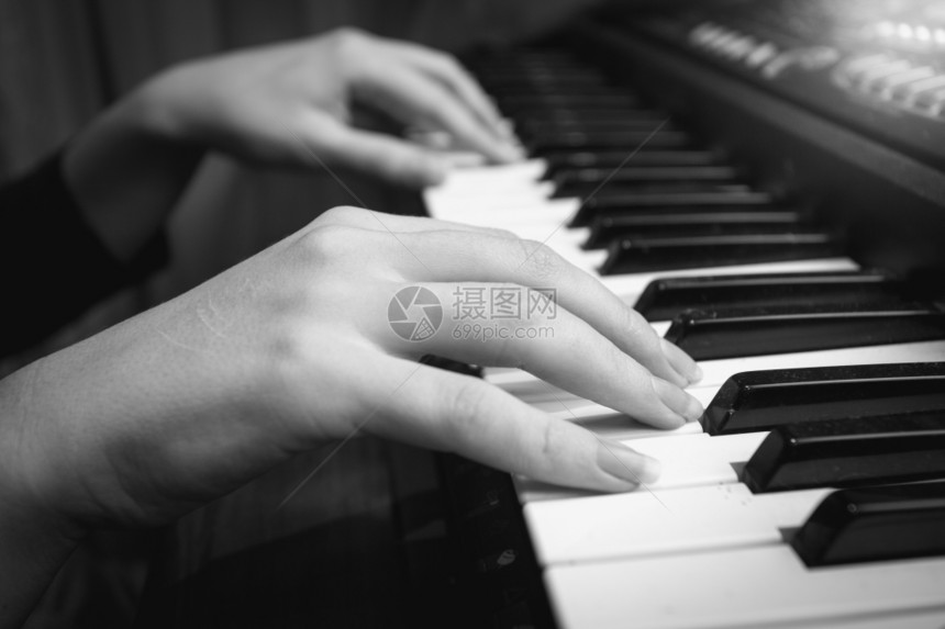 数字钢琴键盘上女手用数字钢琴键盘拍摄的黑白特贴照片图片