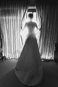 在酒店房间大窗前的优雅年轻新娘黑白照片图片