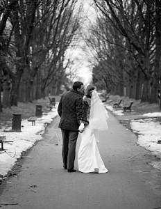 新婚夫妇在冬季公园小巷散步的黑白照片图片