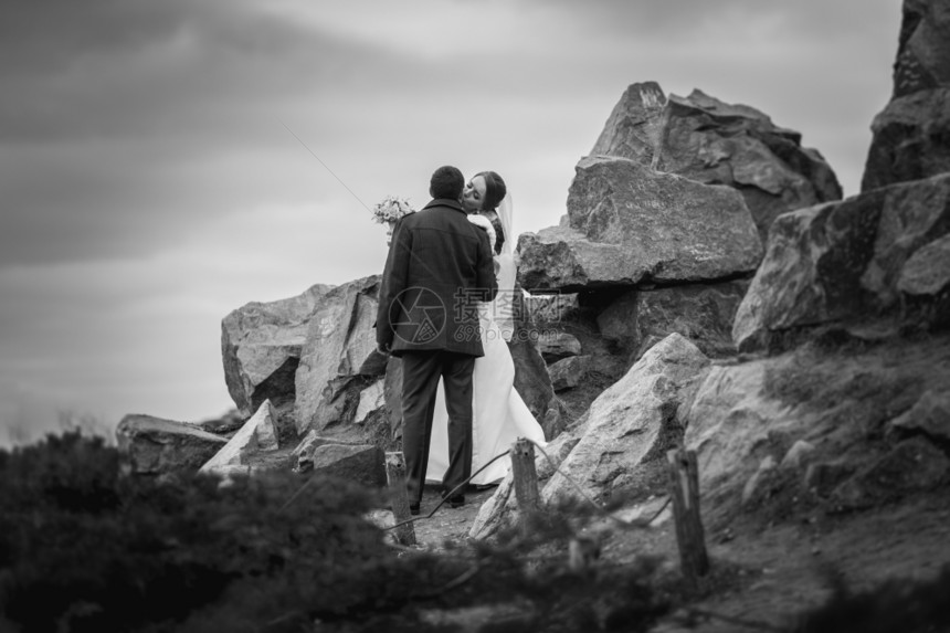在高山上亲吻新娘和郎的黑白照片图片