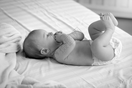 床上尿布中可爱婴儿的黑白照片图片