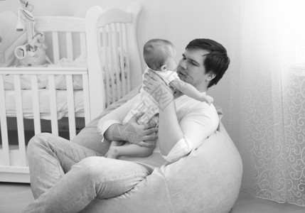 年轻父亲怀着6个月婴儿子的年轻父亲黑白画像图片